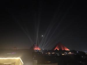 a lit up night sky with a lit up night sky at Pyramid Stars Inn in Cairo