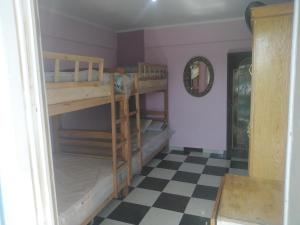 a room with bunk beds and a checkered floor at شقة فندقية - برج نجمة القصر in Marsa Matruh