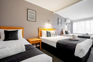 um quarto de hotel com duas camas e uma janela em Best Westlander Motor Inn em Horsham