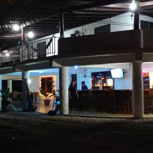 two people standing at a bar at night at Ocean View in Puntarenas