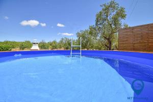 a blue swimming pool with a basketball hoop in it at Casa TiTeresa in Albufeira