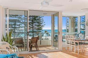 - une salle à manger avec des portes coulissantes en verre donnant sur l'océan dans l'établissement Rainbow Pacific Unit 8, à Gold Coast
