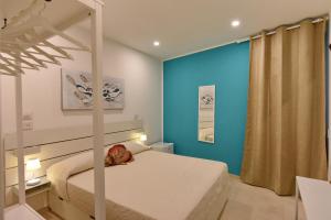 a bedroom with a bed and a blue wall at A' Treglia B&B in Santa Maria di Castellabate