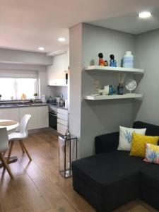 a living room with a couch and a table and a kitchen at Praia da Rocha - Charming Guest House in Portimão