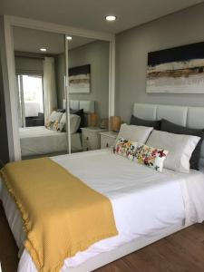 1 dormitorio con 1 cama blanca grande con manta amarilla en Praia da Rocha - Charming Guest House, en Portimão