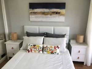 um quarto com uma cama branca com duas mesas de cabeceira em Praia da Rocha - Charming Guest House em Portimão