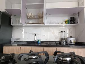 cocina con armarios blancos y encimera en Puerto Azul Club House - Ricaurte Cundinamarca en Ricaurte