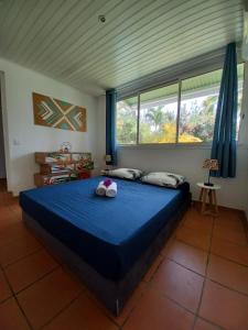 Un dormitorio con una cama azul con dos animales de peluche. en Acerola en Le Vauclin