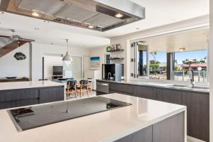 an open kitchen with a large island in the middle at Remarkable Six Bedroom Waterfront Home! Perfect for the extended family in Mooloolaba