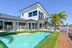 a house with a swimming pool in front of it at Remarkable Six Bedroom Waterfront Home! Perfect for the extended family in Mooloolaba