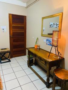 a room with a desk and a mirror and a chair at City Garden Apartment in Belize City
