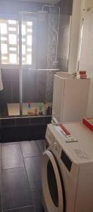 a bathroom with a washing machine and a window at Appartement cosy en plein centre in Guidel