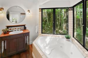 a large bathroom with a tub and a sink at Stoney Creek Cottage in Caravonica