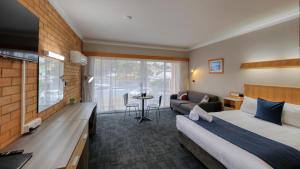 a hotel room with two beds and a couch at Court Street Motel in Parkes