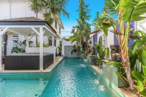 a large swimming pool in a tropical setting at Azur Byron Bay in Byron Bay