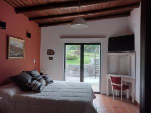 a bedroom with a bed and a sliding glass door at CampoMora- 5 min del Centro - CONFORT - Parrilla & Pileta in San Salvador de Jujuy