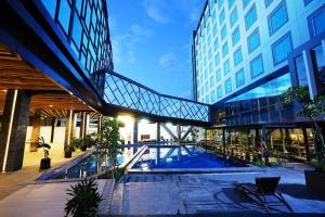 Holiday Inn Bandung Pasteur في باندونغ: مبنى فيه مسبح امام مبنى