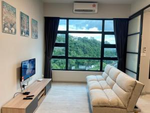 een woonkamer met een bank en een groot raam bij Sunset Seaview Vacation Condos @ Jesselton Quay in Kota Kinabalu