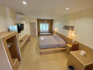 程逸府Baan Suan Palm Resort的卧室里有一张床和一台电视机