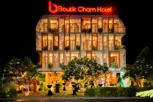 a building with people walking in front of it at night at Boutik Cham NhaTrang Hotel in Nha Trang