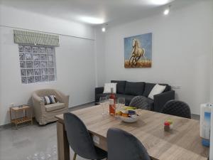 ein Wohnzimmer mit einem Tisch und einem Sofa in der Unterkunft City Aurora in Athen