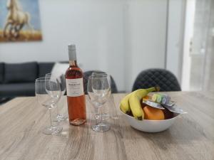 - une bouteille de vin et un bol de fruits sur une table dans l'établissement City Aurora, à Athènes