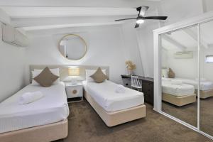 A bed or beds in a room at MOOLOOLABA CANAL HOME - Modern 4Bedroom with Spa, Sauna and Private Pontoon - NEW proprietor 2024