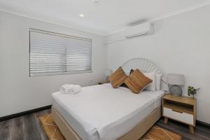 A bed or beds in a room at MOOLOOLABA CANAL HOME - Modern 4Bedroom with Spa, Sauna and Private Pontoon - NEW proprietor 2024