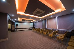 una sala de conferencias con sillas, una pantalla blanca y un podio en B&S Boutique Hotel en Batu Pahat