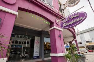 B&S Boutique Hotel في باتو باهات: مبنى وردي مع علامة على الجانب منه