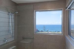 baño con ducha y ventana con vistas. en Coolum Beach Holiday House, en Coolum Beach 12 fotos más