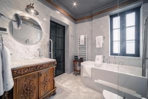 a bathroom with a tub and a sink and a mirror at Bey House Royal Hotel in Veliko Tŭrnovo +34 photos