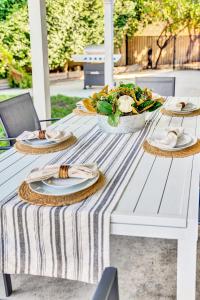 una mesa de picnic blanca con platos de comida. en A Super Private LA home with Amazing Design and Pool & Spa, en San Fernando