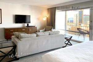 uma sala de estar com um sofá branco e uma televisão em FREE PARKING Waikiki Luxury Ilikai Studio City View em Honolulu