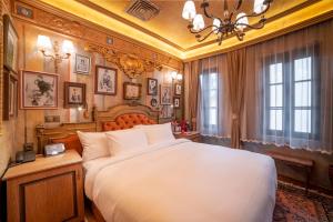 Un dormitorio con una cama grande y una lámpara de araña. en Bey House Royal Hotel en Veliko Tŭrnovo