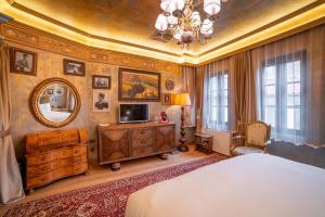 a bedroom with a bed and a mirror at Bey House Royal Hotel in Veliko Tŭrnovo