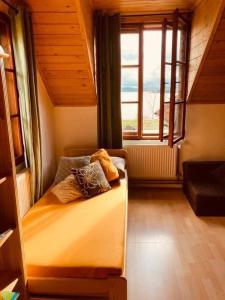 a small room with a bed with a window at Apartmány Srub Jenišov in Horní Planá