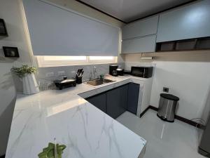 cocina blanca con fregadero y encimera en Fully equipped and furnished apartment and office, 