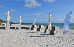 eine Gruppe von Sonnenschirmen und Stühlen am Strand in der Unterkunft Baltic in Binz