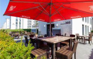 einen Tisch und Stühle mit einem roten Regenschirm auf einer Terrasse in der Unterkunft Baltic in Binz