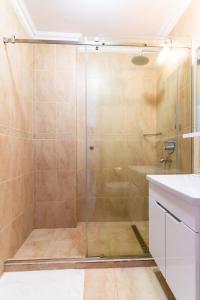 ママイアにあるLuca Solid Residenceのバスルーム(ガラスドア付きのシャワー付)