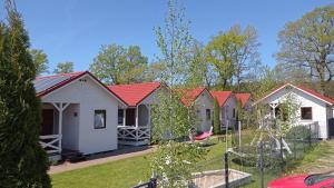 uma fila de casas rústicas com telhados vermelhos em Domki Sowia Polana em Dąbki