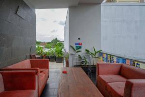 Zimmer mit Sofas und einem Tisch auf einem Gebäude in der Unterkunft Sans Hotel Absari Yogyakarta in Durenan