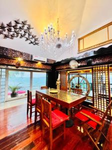 a dining room with a table and chairs and a chandelier at Crystal Sea Villa in Ko Larn