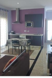 sala de estar con paredes de color púrpura, mesa y sillas en Apartamento Bienvenida, en Bienvenida