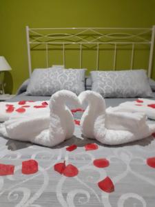 dos cisnes acostados en una cama con flores rojas en Apartamento Bienvenida, en Bienvenida