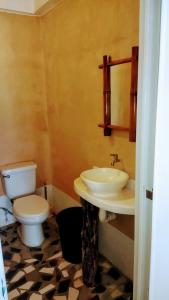 a bathroom with a toilet and a sink at SunnySide bed & bar in Siquijor