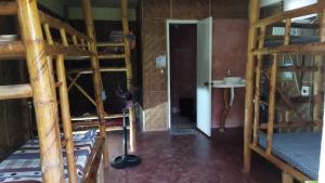 a room with two bunk beds and a bathroom at SunnySide bed & bar in Siquijor