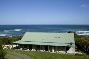 a house with a green roof and the ocean at Bennetts Beach House in Apollo Bay