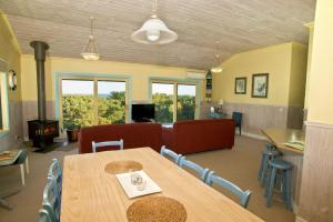 a dining room with a table and chairs and a couch at Bennetts Beach House in Apollo Bay